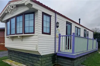 a small house with a purple door and windows at Caravan - Sleeps 4 - Pet friendly - Parking in Newton Stewart