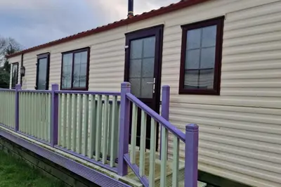 a house with a purple railing and windows at Caravan - Sleeps 4 - Pet friendly - Parking in Newton Stewart