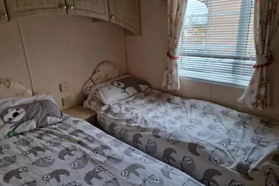 a small bedroom with two beds and a window at Caravan - Sleeps 4 - Pet friendly - Parking in Newton Stewart