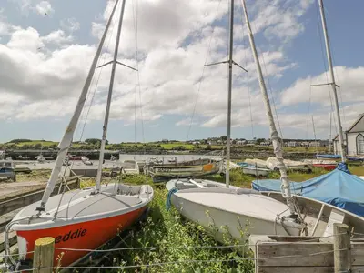 two boats are docked in a harbor at Tides Reach in Newton Stewart