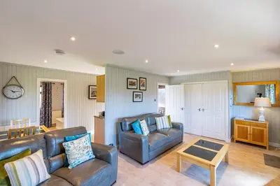 a living room with two couches and a table at Bluebell Lodge 7 with Hot Tub in Newton Stewart