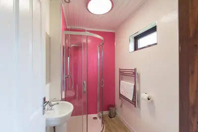 a bathroom with a glass shower and a sink at Bluebell Lodge 9 with Hot Tub in Newton Stewart