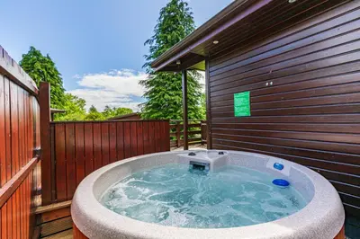 a hot tub on the side of a building at Bluebell Lodge 11 with Hot Tub in Newton Stewart