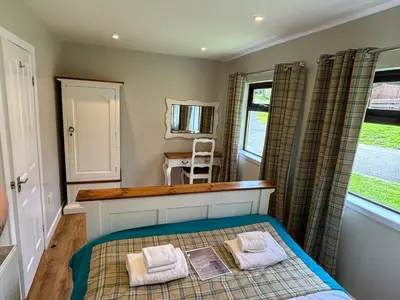 a bedroom with a bed with two towels on it at Bluebell Lodge 11 with Hot Tub in Newton Stewart