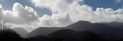 a view of a mountain range with clouds and trees at Loft Apartment, Keswick in Keswick
