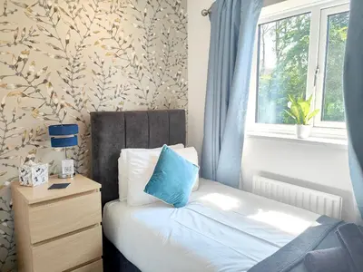 a small bedroom with a bed and a window at Sanderson House in Cleator Moor