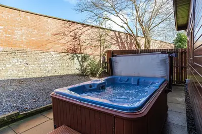 a jacuzzi tub sitting outside of a building at Bluebell Lodge 24 with Hot Tub in Newton Stewart