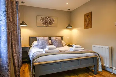 a bedroom with a bed with towels on it at Bluebell Lodge 24 with Hot Tub in Newton Stewart