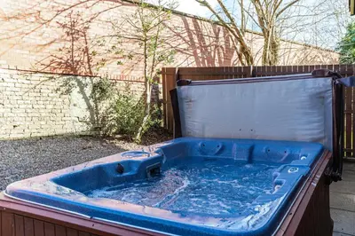 a blue tub in a yard with a fence at Bluebell Lodge 24 with Hot Tub in Newton Stewart
