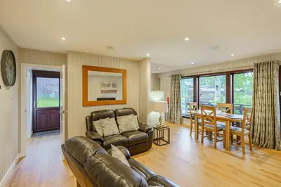 a living room with a couch and a dining room at Birch Lodge 13 with Hot Tub in Newton Stewart