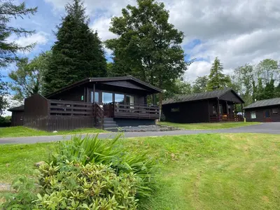 a small house with a porch at Birch Lodge 14 with Hot Tub in Newton Stewart