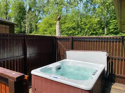 a hot tub on a wooden fence at Birch Lodge 21 with Hot Tub in Newton Stewart