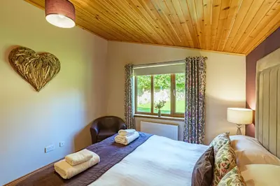 a bedroom with a large bed with a heart on the wall at Laurel Lodge 6 with Hot Tub in Newton Stewart