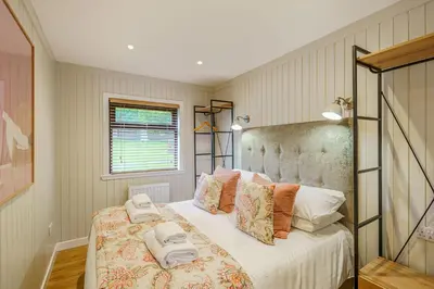 a bedroom with a bed with towels on it at Conifer Lodge 8 with Hot Tub in Newton Stewart