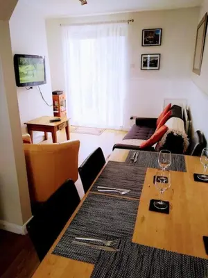 a living room with a table with wine glasses on it at 2 Bed pet-free cottage, private garden & fell view in Arlecdon