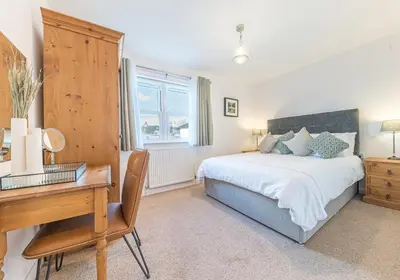 a bedroom with a bed and a desk and a desk at Lilac Cottage in Keswick