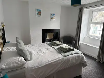 a bedroom with a white bed with two pillows on it at 17 Main Street in St Bees