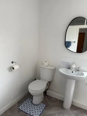 a white bathroom with a toilet and a sink at 17 Main Street in St Bees