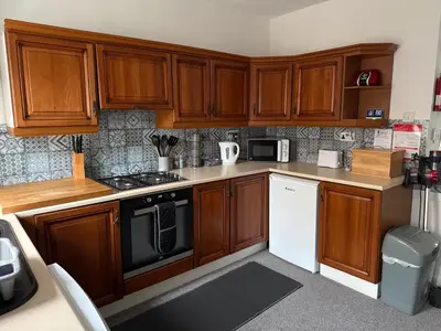 a kitchen with wooden cabinets and a stove top oven at 17 Main Street in St Bees