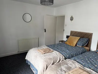 a bedroom with two beds and a clock on the wall at 18 Main Street in St Bees