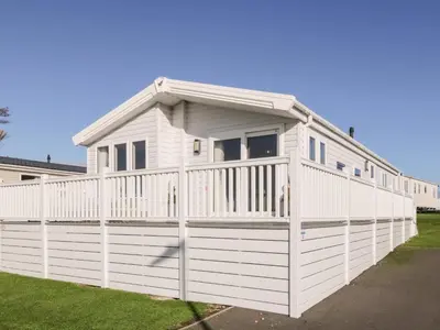 a white house with a white fence at Dershel Lodge in Dumfries