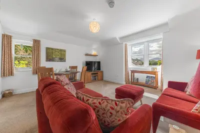 a living room with a red couch and chairs at Felltops in Keswick