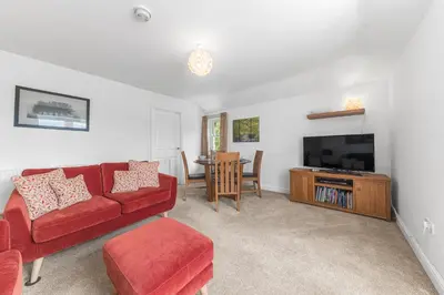 a living room with a red couch and a television at Felltops in Keswick