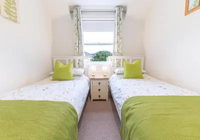 two twin beds in a room with a window at Felltops in Keswick