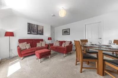 a living room with red furniture and a table at Felltops in Keswick