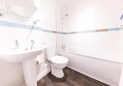 a white bathroom with a toilet and a sink at Felltops in Keswick