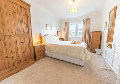 a bedroom with a large bed and a window at 16 Greta Grove House in Keswick