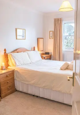 a bedroom with a large bed and a window at 16 Greta Grove House in Keswick