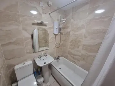 a bathroom with a sink and a toilet and a bath tub at 5 Greta Side Court in Keswick
