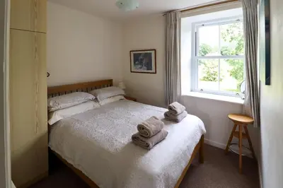 a bedroom with a bed with towels on it at 5 Greta Side Court in Keswick