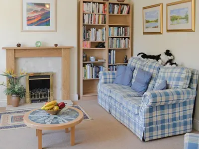 a living room with a couch and a table with a bowl of fruit at 9 Greta Grove House in Keswick