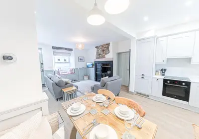 a kitchen and living room with a table and chairs at Brandelhowe in Keswick
