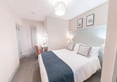 a bedroom with a large white bed with pillows at Brandelhowe in Keswick