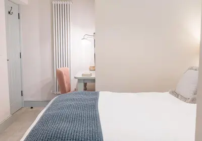 a bedroom with a bed and a desk with a lamp at Brandelhowe in Keswick