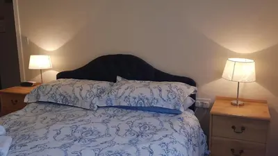 a bed with a blue and white comforter and two lamps at Catbells in Keswick