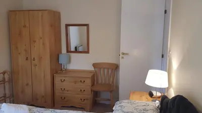 a bedroom with a bed and a dresser and a mirror at Catbells in Keswick