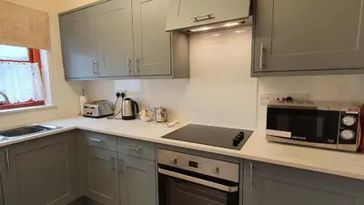 a kitchen with a counter top with a microwave at Catbells in Keswick