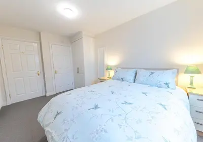 a bedroom with a large bed with blue flowers on it at Latrigg View in Keswick