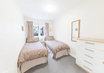 a bedroom with two beds and a mirror at Latrigg View in Keswick