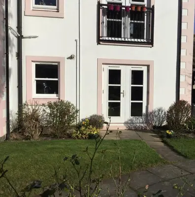 a white house with a balcony and a door at Latrigg View in Keswick