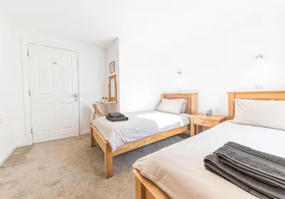a bedroom with two beds and a door at Riverside View in Keswick
