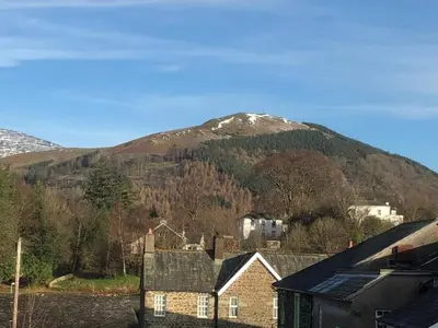 a mountain in the distance with a town and houses at Skiddaw. 20 Greta Grove House in Keswick