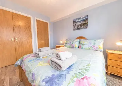 a bedroom with a bed with towels on it at Tiggs Place, 5 Howrahs Court in Keswick