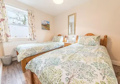 a bedroom with two beds and a window at Tiggs Place, 5 Howrahs Court in Keswick