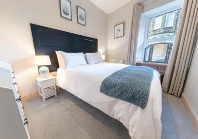 a bedroom with a large white bed and a window at Withesike, Derwent House in Keswick