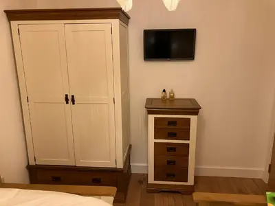 a bedroom with a white cabinet and a dresser at Cherry Tree Cottage in Stranraer